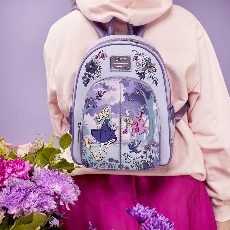 Image of someone wearing pink and wearing the Loungefly Disney Sleeping Beauty 65th Anniversary Floral Scene Mini Backpack 